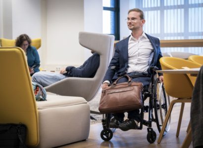 Rijksmedewerker in rolstoel kijkt naar rechts